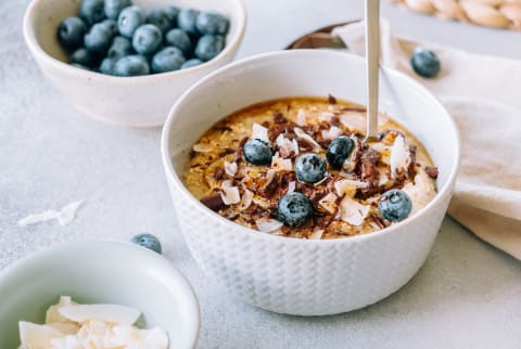 Porridge Topped With Caramelized Banana, Chocolate, Shredded Coconut And Blueberries